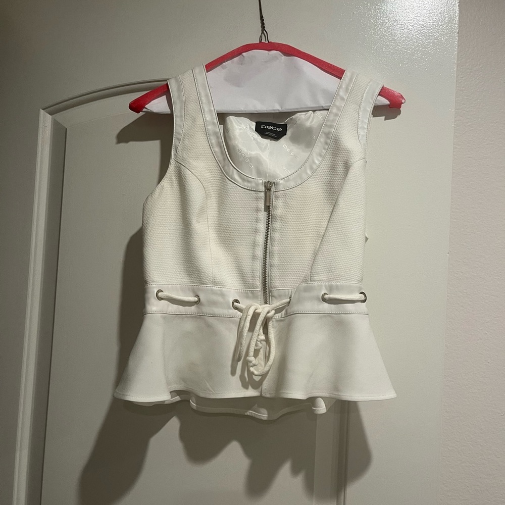Beautiful fitted top with leather trim around neck area .
